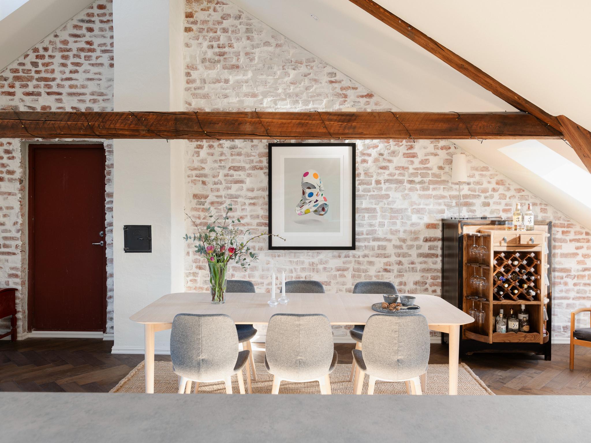 I stuen/spisestuen er det flotte detaljer som synlige takbjelker, fiskebensgulv og eksponert teglsteinsvegg.